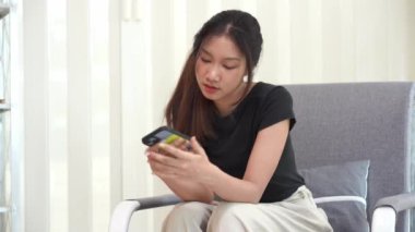 İnternetten akıllı telefondan alışveriş yapan Asyalı bir kadın uygulamadan sipariş vermiş ve ürünü kredi kartıyla ödemiş..