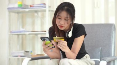 İnternetten akıllı telefondan alışveriş yapan Asyalı bir kadın uygulamadan sipariş vermiş ve ürünü kredi kartıyla ödemiş..