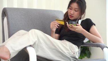 İnternetten akıllı telefondan alışveriş yapan Asyalı bir kadın uygulamadan sipariş vermiş ve ürünü kredi kartıyla ödemiş..