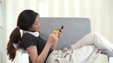 İnternetten akıllı telefondan alışveriş yapan Asyalı bir kadın uygulamadan sipariş vermiş ve ürünü kredi kartıyla ödemiş..