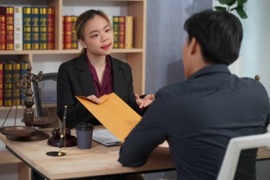 Avukat ve yetkililerden oluşan bir grup, adalet ve karar verme mekanizmasını sembolize eden çekiç ve teraziyle belgeleri kontrol ediyor.