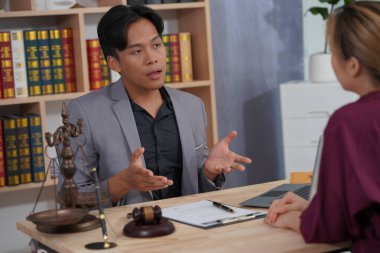 Avukat ve yetkililerden oluşan bir grup, adalet ve karar verme mekanizmasını sembolize eden çekiç ve teraziyle belgeleri kontrol ediyor.