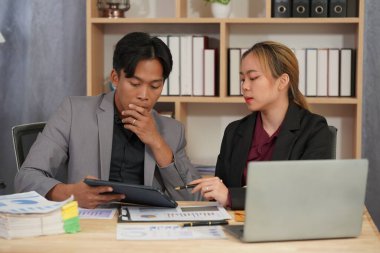 Finansal Analiz: Yatırımları iş planına göre değerlendiren mali raporları planlamak ve analiz etmek üzere tablet ve belgelerle birlikte çalışan iş ekibi.