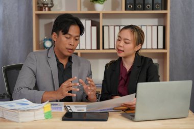 Bir emlak satış temsilcisi gayrimenkul yatırım belgelerinin yanı sıra ev satış sözleşmesi ve ev sigortasını müşterilere açıklamak için konuşur.