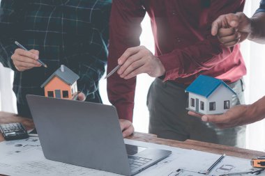 Bir grup mimar ev tasarımlarını ve ev modellerini planlar ve onaylar. Mimari çizimler, planlar, planlar, planlar, yakın plan resimler tasarlar.