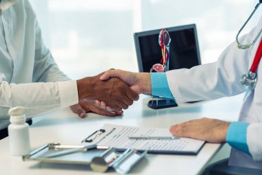 Genç bir adam muayene odasında ereksiyon bozukluğunun nedenleri hakkında bir doktora danışıyor. Erkek hasta oturur ve prostat kanseri konusunda doktora danışır. ve idrar yolu enfeksiyonu.