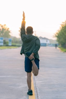 Parkta koşan bir adam güneşli bir günde koşar Gülümser ve açık hava aktiviteleriyle, motivasyonla, fitness ile, egzersizle eğlenir. Koşup gidenlere,