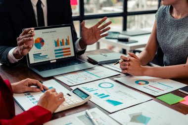 Mali raporlar, çizelgeler ve veri analizinin yer aldığı bir iş toplantısı veya tartışma. Katılımcılar, büyük olasılıkla performans ölçümleri veya stratejileri tartışan görsel bir sunumu gözden geçiriyorlar.