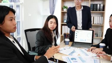 Genç Asyalı girişimciler, iş girişimlerini planlamak için tabletler ve dizüstü bilgisayarlarda, haritalarda sergilenen mali belgeler ve grafiklerde yer alan yeni iş projelerini görüşmek üzere bir araya geldiler..