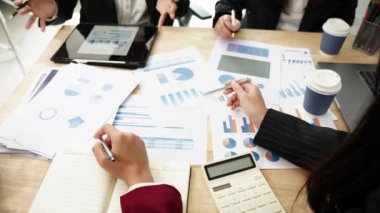 Genç Asyalı girişimciler, iş girişimlerini planlamak için tabletler ve dizüstü bilgisayarlarda, haritalarda sergilenen mali belgeler ve grafiklerde yer alan yeni iş projelerini görüşmek üzere bir araya geldiler..