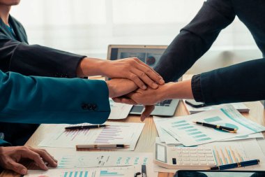 Ofiste siyah takım elbiseli iş adamları el sıkışıyor. İş adamları ve meslektaşları başarılı bir ortaklığı masa ve dizüstü bilgisayar grafikleriyle sıcak bir tokalaşmayla kutluyorlar. Kapat..