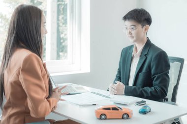 Araba sigortacısı müşterileri küçük araba ve araba anahtarlarıyla, satış konseptiyle, kaza sigortasıyla, araba bayiiyle tanıştırır.