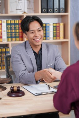 Anlaşmaya vardıktan sonra iki neşeli avukat ofiste başarılı müzakereleri kutluyor. dikey resim