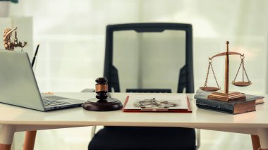 Çevrimiçi hukuk ve adalet kavramı modern ofisteki masada. Masadaki ahşap çekiç ve adalet terazisinin yanında yakın plan bir figür var.