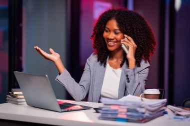 Cep telefonuyla konuşan genç Afrikalı kadın ofisteki müşteri destek ürünleri hakkında danışmanlık yapmayı düşün..