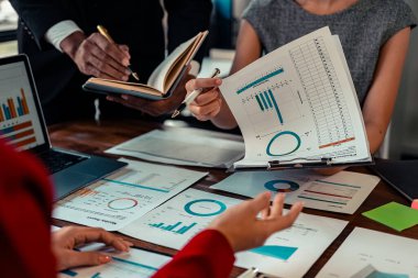 Bir grup finans analisti şirket mali istatistik raporlarını tartışmak için birlikte çalışıyorlar. Belgelerle beyin fırtınası, masadaki grafikler, yakın plan resim