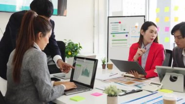 Bir grup genç iş adamı ofiste bir masada oturup kağıt raporlarını ve grafik belgelerini tartışıyor. Fikirleri paylaşın, kararlar verin ve iş sorunlarına beyin fırtınası çözümleri getirin..