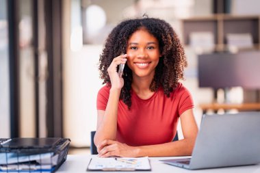 Akıllı telefon teknolojisi ve dizüstü bilgisayar ve grafik dokümanlarını kullanarak projenin son teslim tarihine kadar çalışmak üzere gece çalışan Afrikalı kadın çalışanlar