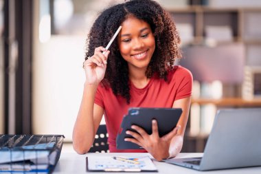 Akıllı telefon teknolojisi ve dizüstü bilgisayar ve grafik dokümanlarını kullanarak projenin son teslim tarihine kadar çalışmak üzere gece çalışan Afrikalı kadın çalışanlar