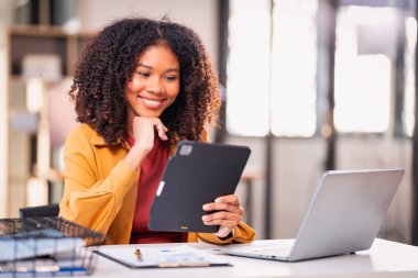 Akıllı telefon teknolojisi ve dizüstü bilgisayar ve grafik dokümanlarını kullanarak projenin son teslim tarihine kadar çalışmak üzere gece çalışan Afrikalı kadın çalışanlar