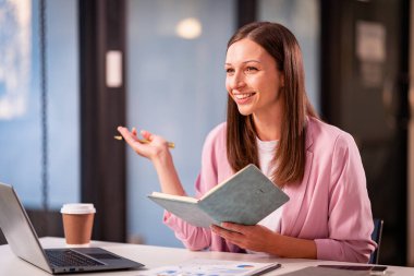 Bokeh ışıkları ile çalışan kadın çalışan, dizüstü bilgisayar teknolojisini kullanarak projenin son teslim tarihine göre fazla mesai yapıyor. finansal grafik belgesi