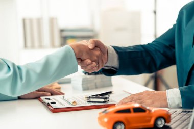 Araba alıcısı elektrikli araba galerisinde satıcıyla el sıkışıyor, işadamı yeni bir araba seçmek ve satın almak için fikir alışverişinde bulunuyor, yakın plan.