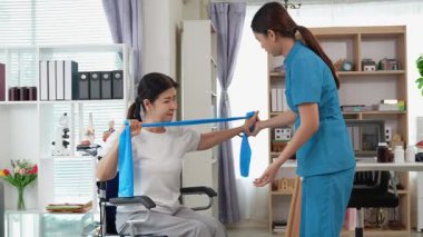 Asyalı kadın fizyoterapist, kas dokusu zedelenmesi olan yaşlı bir kadın hastayla ilgileniyor..