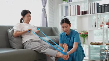 Asyalı kadın fizyoterapist, kas dokusu zedelenmesi olan yaşlı bir kadın hastayla ilgileniyor..