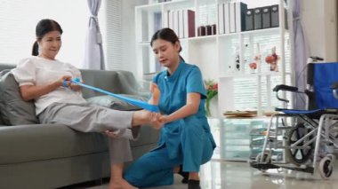 Asyalı kadın fizyoterapist, kas dokusu zedelenmesi olan yaşlı bir kadın hastayla ilgileniyor..