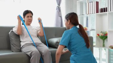 Asyalı kadın fizyoterapist, kas dokusu zedelenmesi olan yaşlı bir kadın hastayla ilgileniyor..