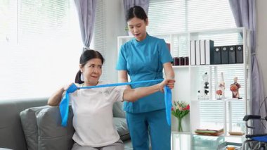 Asyalı kadın fizyoterapist, kas dokusu zedelenmesi olan yaşlı bir kadın hastayla ilgileniyor..