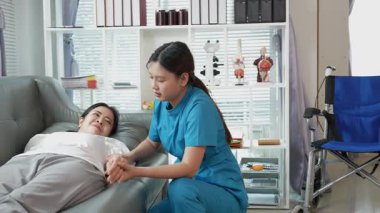 Asyalı kadın fizyoterapist, kas dokusu zedelenmesi olan yaşlı bir kadın hastayla ilgileniyor..