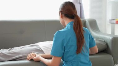 Asyalı kadın fizyoterapist, kas dokusu zedelenmesi olan yaşlı bir kadın hastayla ilgileniyor..