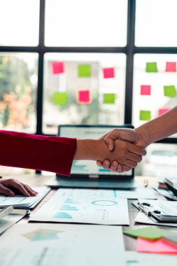 İş adamları birleşme ve ortaklarla iş anlaşmasını kutlamak için takım olarak çalışarak el sıkışıyor. Kapat..