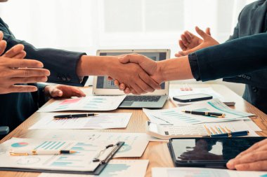 İş adamları birleşme ve ortaklarla iş anlaşmasını kutlamak için takım olarak çalışarak el sıkışıyor. Kapat..