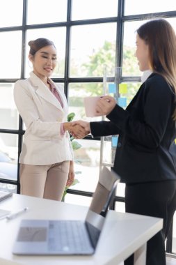 İş kadınları toplantı sırasında anlaşmaya vardıktan sonra el sıkışırlar. Ve birlikte çalışarak başarıyı kutlarız. Birlikte elde ettiğimiz sonuçlarla gurur duyarız.