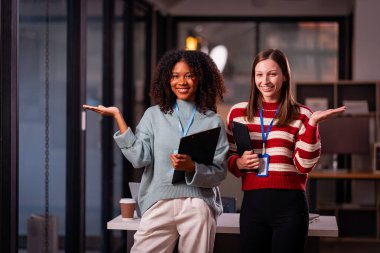 Takım çalışması laptoplu iki kadın makaleler, iş birlikleri ve mesai sonrası toplantılar için araştırma yapıyorlar..