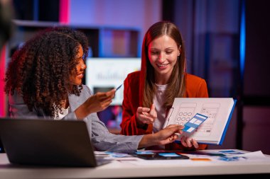 İki kadın UI / UX tasarımcısı hem kağıt hem de dijital kablolar üzerinde mobil uygulama arayüzleri tasarlama hakkında konuşmak için birlikte çalışıyorlar. Web sitelerini ya da mobil uygulamaları analiz edin ve tartışın.