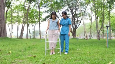 Genç bir Asyalı doktor yaşlı bir kadını parkta yürüyüşe çıkarıyor. Doğal terapi konsepti. Yaşlıların bakıcısı veya çalışanı.