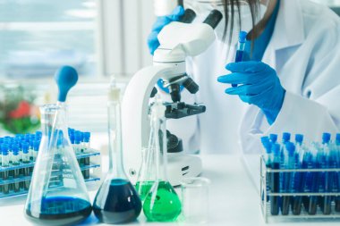 Bilimadamları ve mikroskoplar tıbbi araştırmalar, yenilikler veya aşı laboratuvarlarında analizler için.