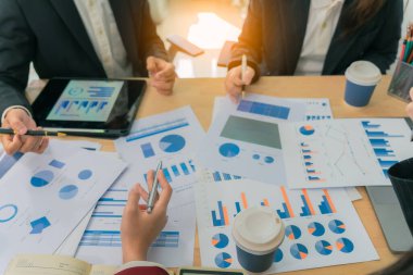 Yakın bir belgedeki belirli veri noktalarına işaret etmek için kalem kullanarak, yeni iş projeleri için harita ve grafikleri tartışacak ve analiz edecek finansal ve yatırım fikirleri üzerinde çalışmak ve beyin fırtınası yapmak.