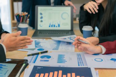 Yakın bir belgedeki belirli veri noktalarına işaret etmek için kalem kullanarak, yeni iş projeleri için harita ve grafikleri tartışacak ve analiz edecek finansal ve yatırım fikirleri üzerinde çalışmak ve beyin fırtınası yapmak.