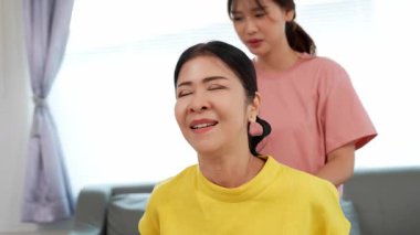 Rehabilitasyon yapan yaşlı bir kadın veya hastanın eklem ağrısı tedavisi, eklem iltihabı olan hastaya destek, genç kızın yardımıyla omuz hareketliliği testi