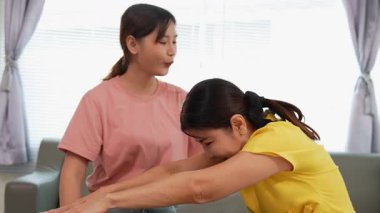 Rehabilitasyon yapan yaşlı bir kadın veya hastanın eklem ağrısı tedavisi, eklem iltihabı olan hastaya destek, genç kızın yardımıyla omuz hareketliliği testi