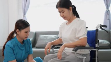 Asyalı kadın doktor yaşlı kadın hastalarla ilgilenir, fizik tedaviye yardım eder, lastik tüplerle esnetir, ve sağlık, danışmanlık ve egzersiz için diz ağrısı, spor yaralanmaları,.