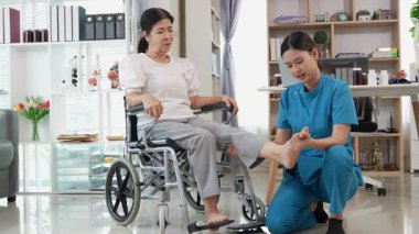 Asyalı kadın doktor yaşlı kadın hastalarla ilgilenir, fizik tedaviye yardım eder, lastik tüplerle esnetir, ve sağlık, danışmanlık ve egzersiz için diz ağrısı, spor yaralanmaları,.