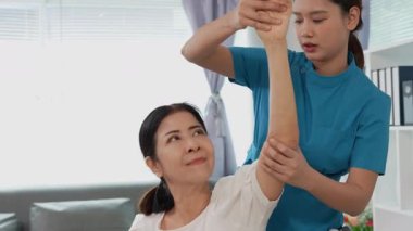 Asyalı kadın doktor yaşlı kadın hastalarla ilgilenir, fizik tedaviye yardım eder, lastik tüplerle esnetir, ve sağlık, danışmanlık ve egzersiz için diz ağrısı, spor yaralanmaları,.