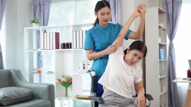 Asyalı kadın doktor yaşlı kadın hastalarla ilgilenir, fizik tedaviye yardım eder, lastik tüplerle esnetir, ve sağlık, danışmanlık ve egzersiz için diz ağrısı, spor yaralanmaları,.