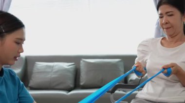 Asyalı kadın doktor yaşlı kadın hastalarla ilgilenir, fizik tedaviye yardım eder, lastik tüplerle esnetir, ve sağlık, danışmanlık ve egzersiz için diz ağrısı, spor yaralanmaları,.
