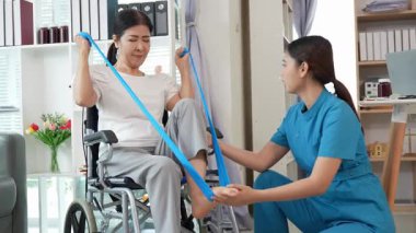 Asyalı kadın doktor yaşlı kadın hastalarla ilgilenir, fizik tedaviye yardım eder, lastik tüplerle esnetir, ve sağlık, danışmanlık ve egzersiz için diz ağrısı, spor yaralanmaları,.